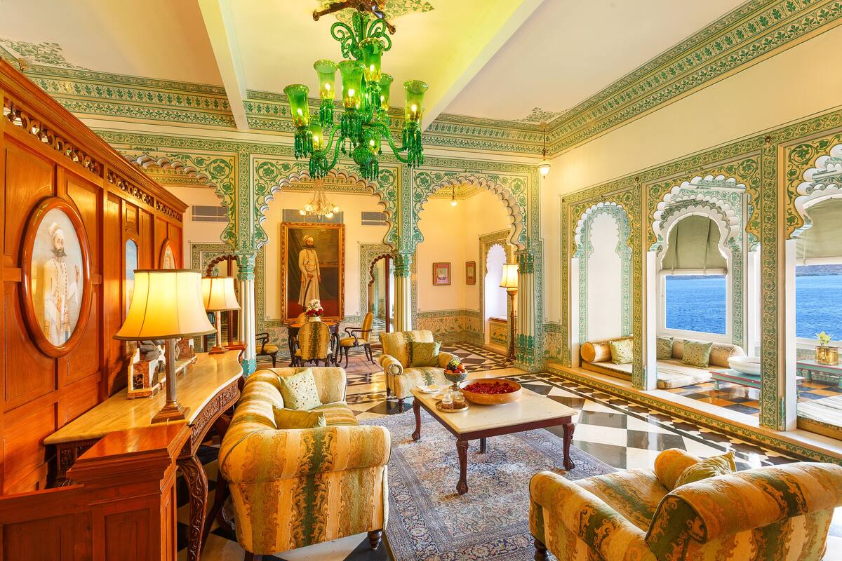 Un hall d’entrée luxueux, agrémenté d’une décoration somptueuse aux tons verts et dorés, d’un magnifique lustre et offrant une vue sur la mer.