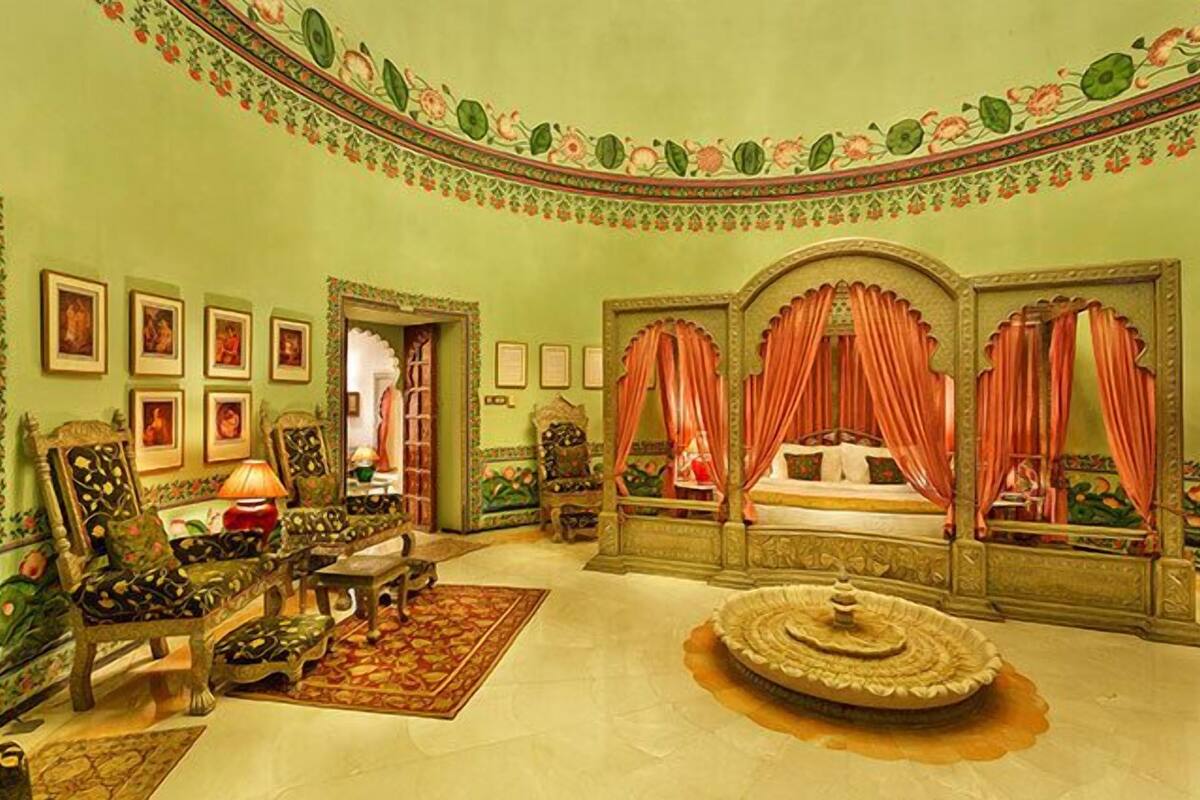Une chambre de style traditionnel, dotée d’un lit à baldaquin, de meubles richement décorés et d’une fontaine ornementale.