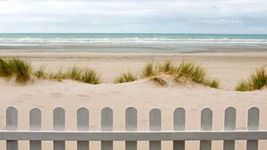 A beach with a wooden fence in the foreground and a cloudy sky. - ibis Le Touquet Thalassa (Le Touquet-Paris-Plage)