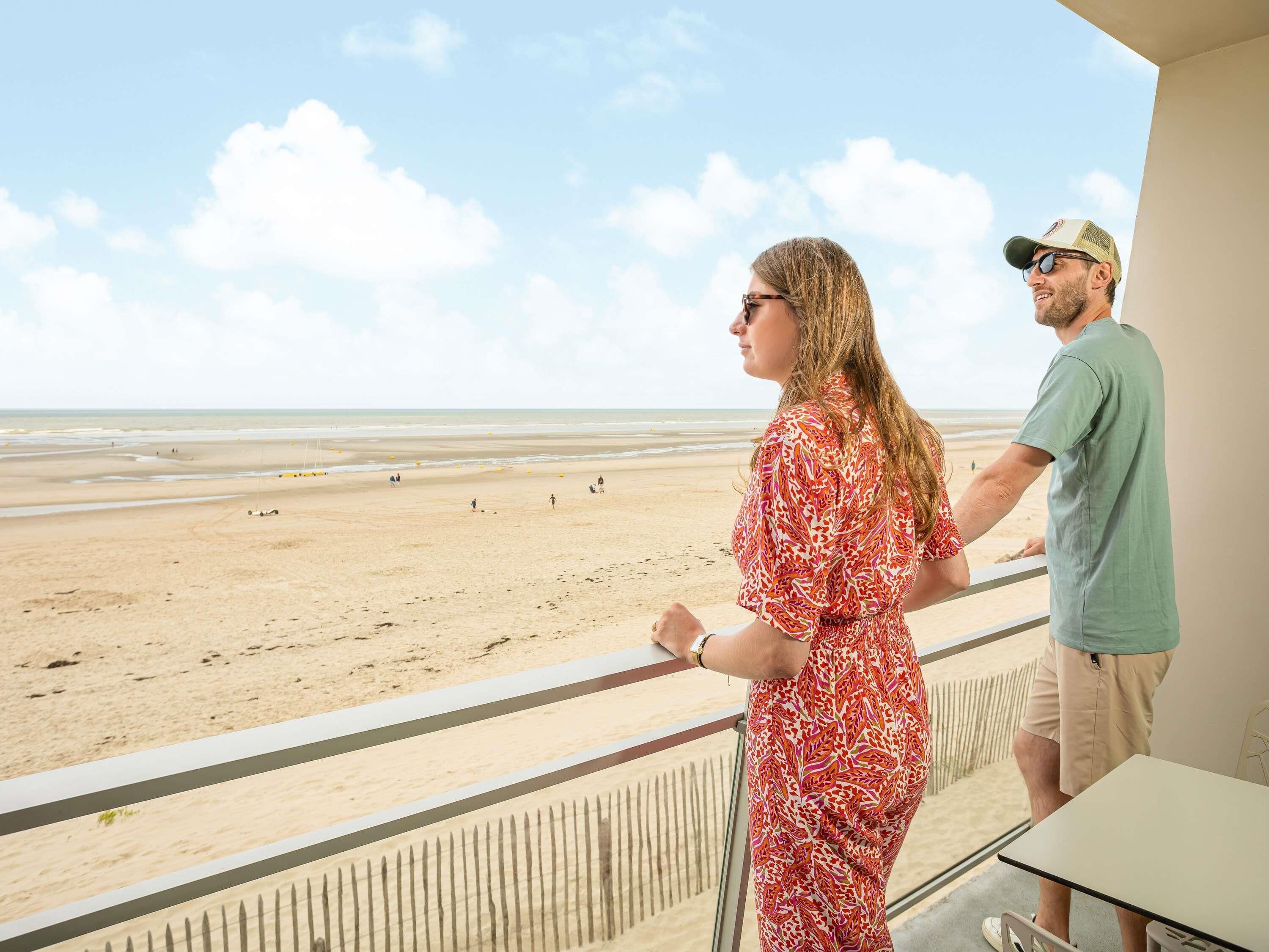 A balcony with a view of a beach.