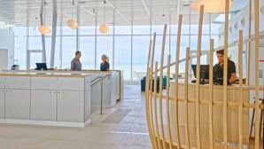 A modern reception area with a counter, seating, and large windows. - ibis Le Touquet Thalassa (Le Touquet-Paris-Plage)