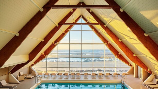 An indoor swimming pool with a view of the beach, wooden beams, and sun loungers. - ibis Le Touquet Thalassa (Le Touquet-Paris-Plage)