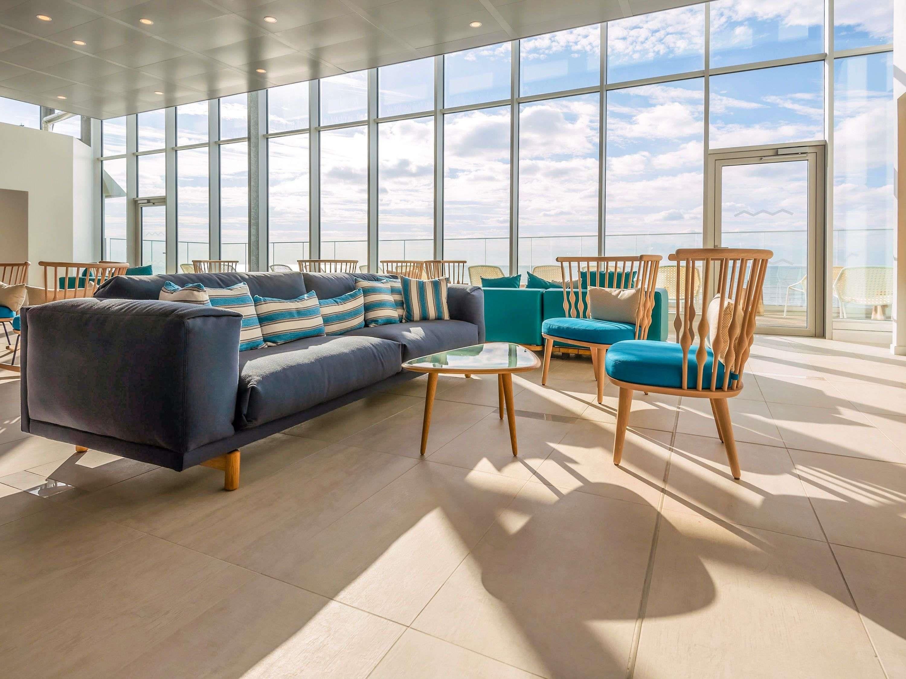 Un espace détente moderne comprenant un canapé, des fauteuils et une table basse.