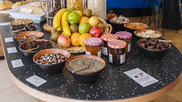 Een ontbijtbuffet met diverse gerechten en een zithoek op de achtergrond.