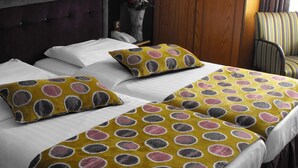 A hotel room with two beds, each with white bedding and a yellow polka dot throw blanket. - Glen Guesthouse (Dublin)