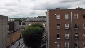 A multi-story building with a brick facade, several windows, and a flagpole. - Glen Guesthouse (Dublin)