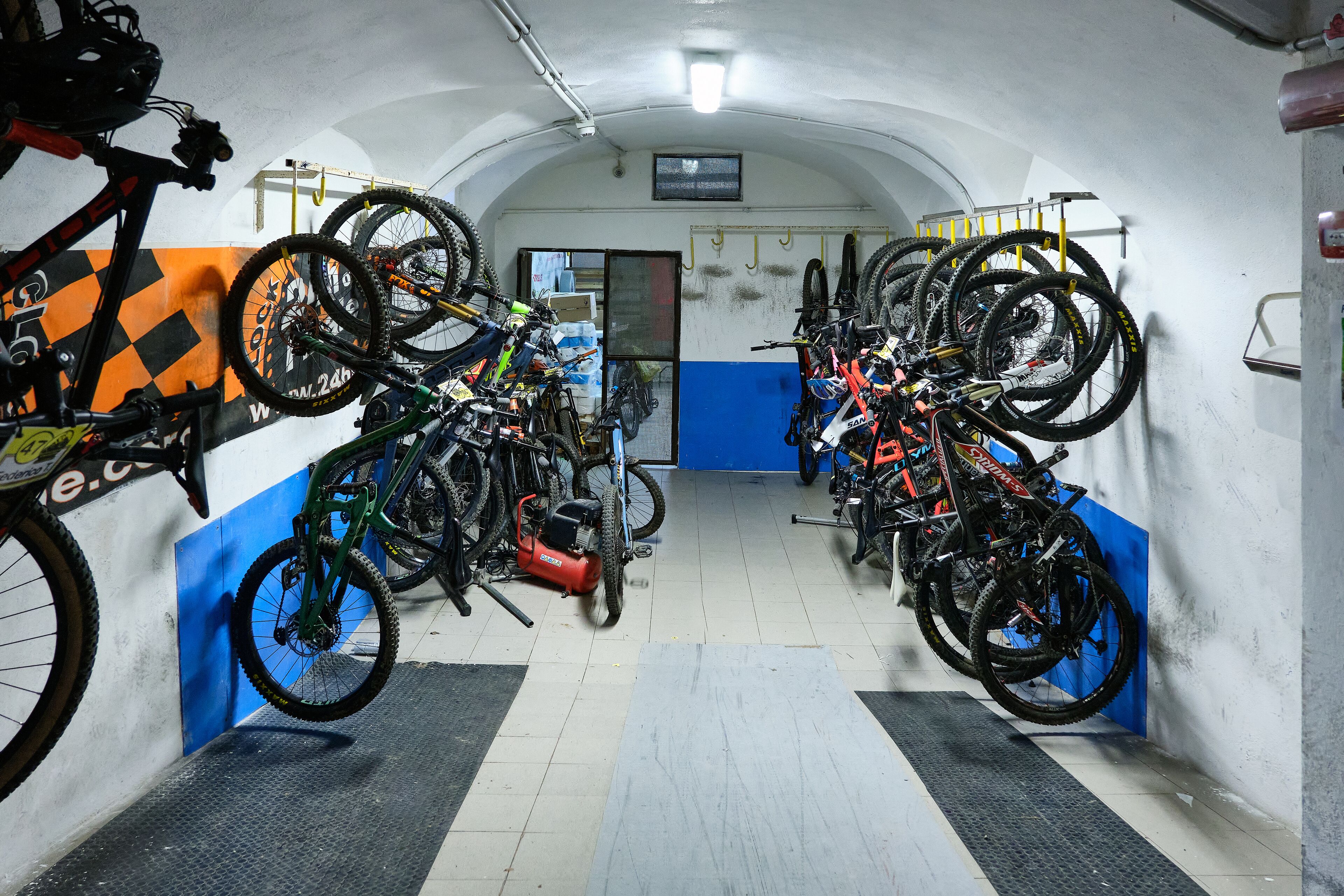 A bike storage area with multiple bicycles and a tire repair station.