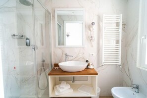 A bathroom with a large white sink, a mirror, a shower, and a toilet. - Continental (Pietra Ligure)