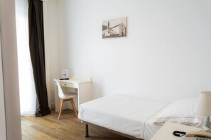 A hotel room with a bed, a desk, a chair, a lamp, and a picture on the wall. - Continental (Pietra Ligure)