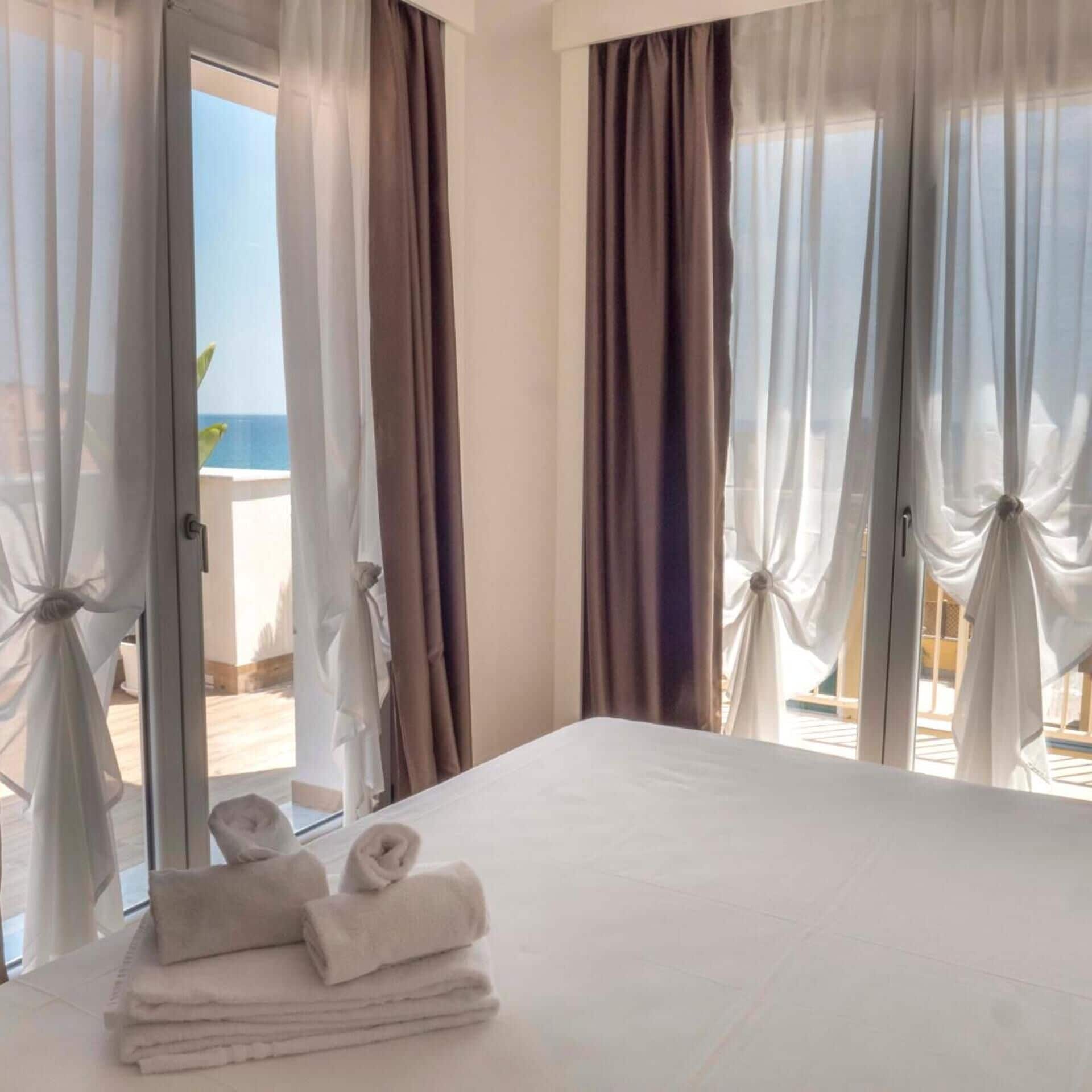 Une chambre d’hôtel avec un lit, une porte et des rideaux.