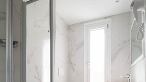 A bathroom with a glass shower enclosure, a sink with a vessel basin, and a toilet. - Continental (Pietra Ligure)