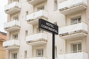 Un edificio a più piani con balconi e un cartello che recita 'HOTEL CONTINENTAL'.