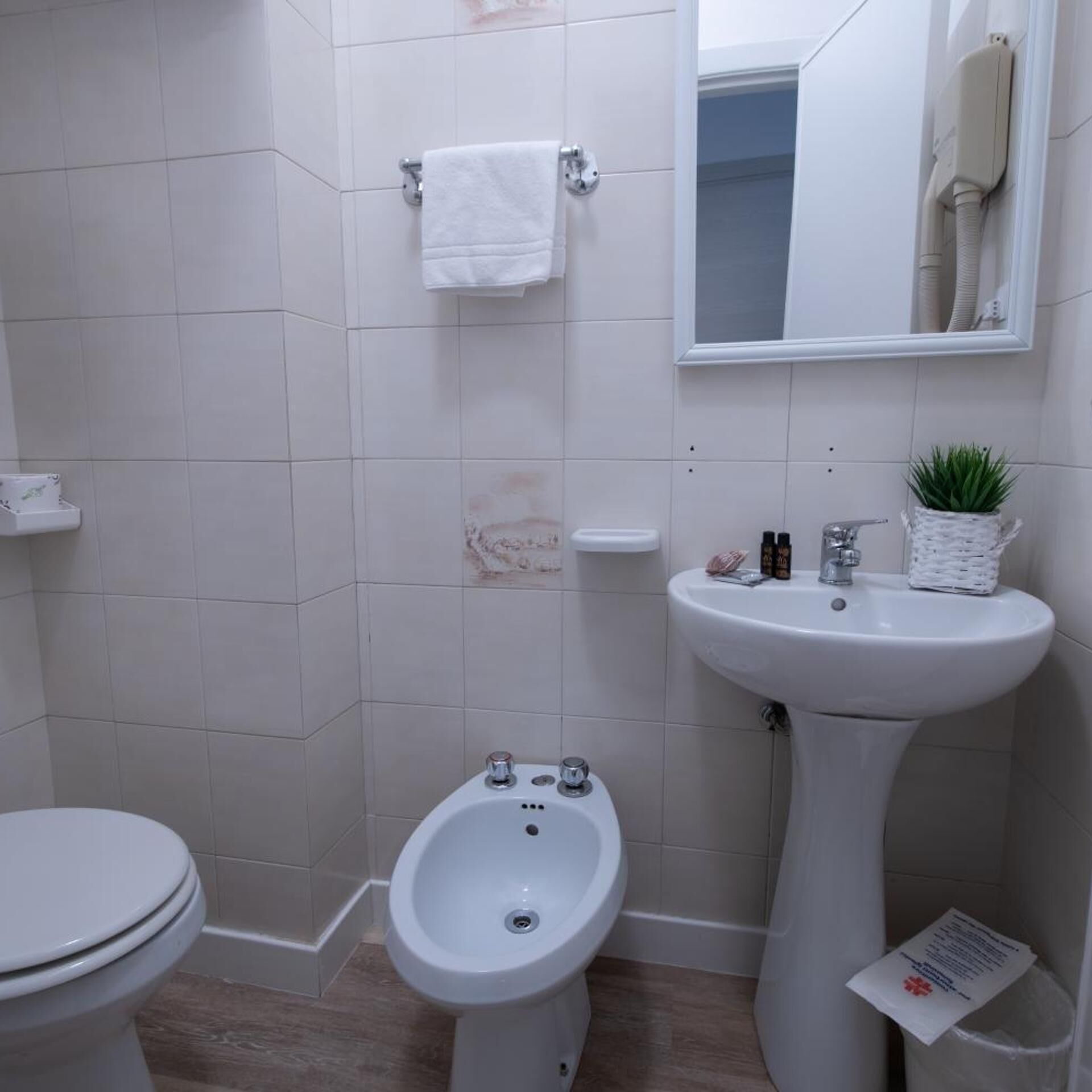 A bathroom with a toilet, bidet, and sink.
