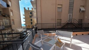 A balcony with a table, chairs, and a small decorative item. - Continental (Pietra Ligure)