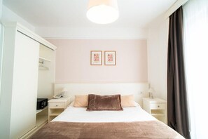 A hotel room with a bed, bedside tables, a wardrobe, and a ceiling light. - Continental (Pietra Ligure)