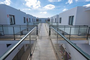 A modern hotel corridor with glass railings and a central walkway. - THB Flora Aparthotel (Tías)