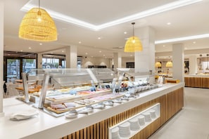 A modern breakfast buffet with a variety of food items, a clean and spacious layout, and stylish pendant lighting. - THB Flora Aparthotel (Tías)