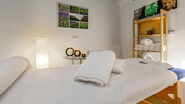A room with two beds, a wall-mounted shelf with towels, a framed photo collage, and a lamp. - THB Flora Aparthotel (Tías)