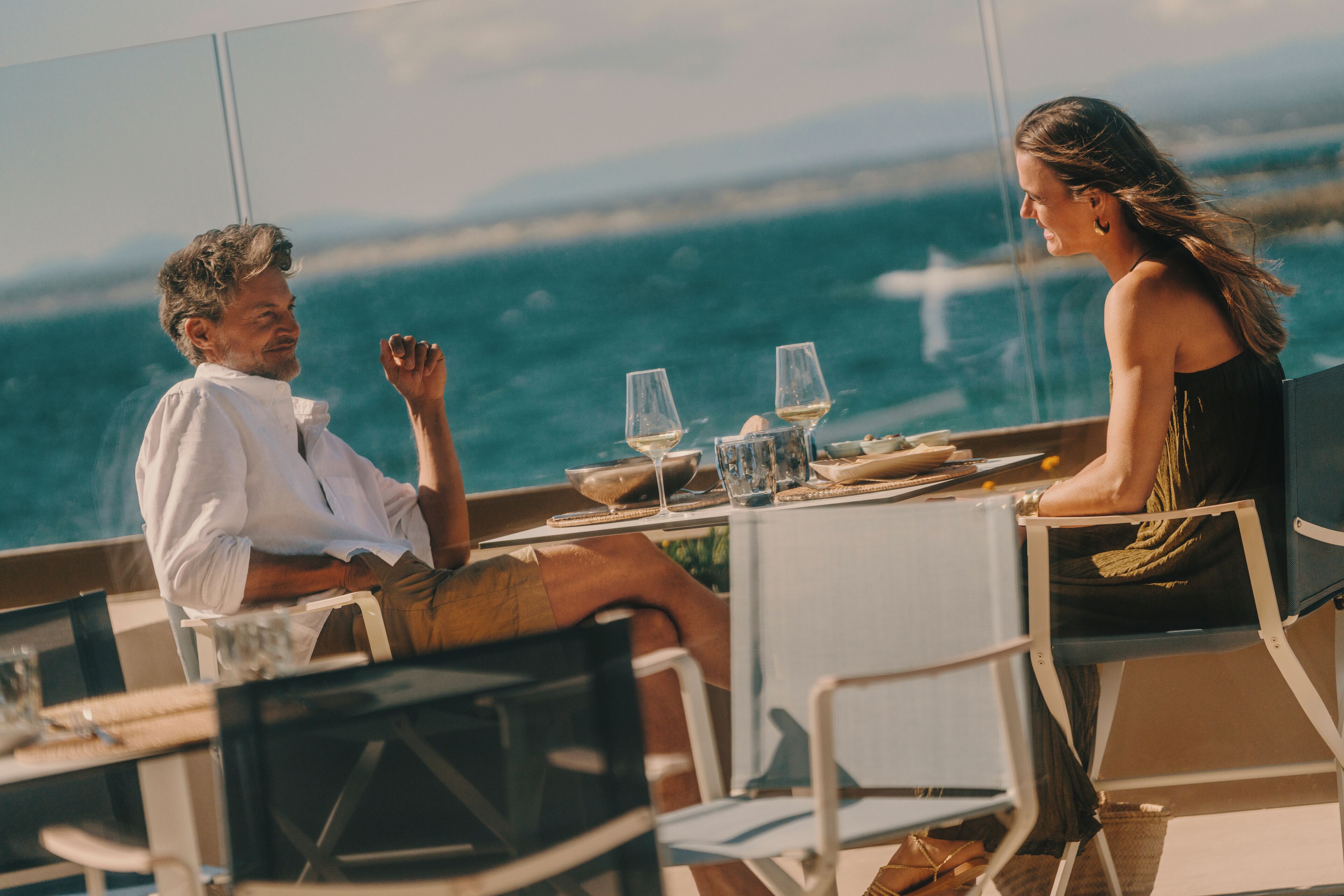 A couple dining at a table with a view of the ocean.
