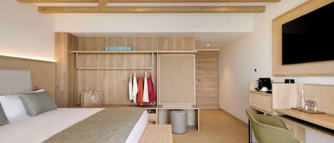 Una habitación de hotel moderna con una cama grande, un escritorio, un armario y un televisor.