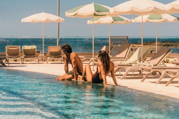 Seasonal outdoor pool, open 10:00 AM to 6:00 PM, pool umbrellas
