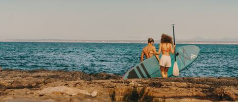 A rocky beach with a wooden walkway leading to the sea.