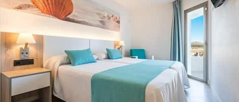 A hotel room with a bed, two bedside tables, a TV, and a large window with a view.
