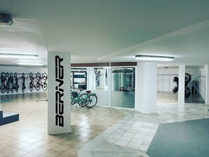 Un vaste espace intérieur doté d’un sol carrelé, d’une grande colonne sur laquelle est inscrit le mot « BERNER », et de plusieurs vélos fixés au mur.