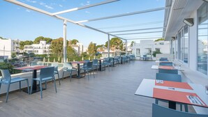 Eine Dachterrasse mit Sitzgelegenheiten im Freien, einem Pool und Blick auf die Stadt.
