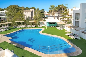 Una piscina con tumbonas y un carrito de aperitivos.