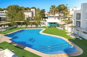 Una piscina cubierta, una piscina al aire libre, sombrillas, tumbonas