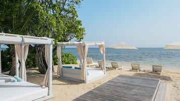 Am Strand, weißer Sandstrand, Liegestühle, Strandtücher