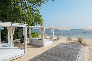 Sur la plage, sable blanc, chaise longue, serviettes de plage
