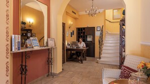 A spacious living area with a staircase, a dining table with a vase of flowers, and a woman working at a desk. - Villa Pattiera (Konavle)