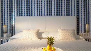 Una habitación de hotel con una cama grande, ropa de cama blanca y una piña sobre la cama.
