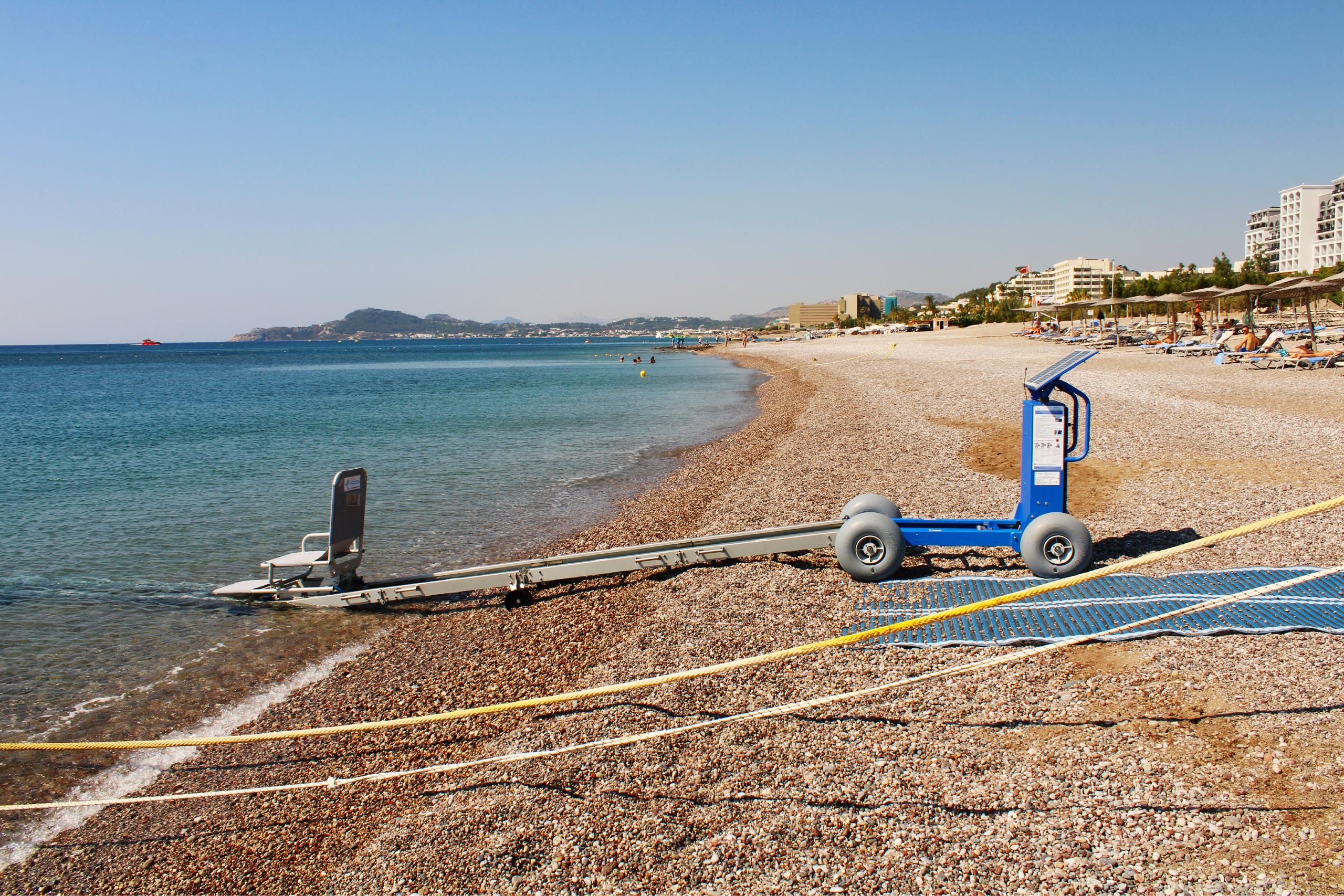 A beach with a jet ski, a lifeguard stand, and a row of beach chairs.