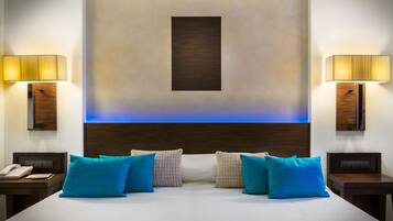 Una habitación de hotel moderna con una cama grande, dos mesitas de noche, un teléfono y dos lámparas.