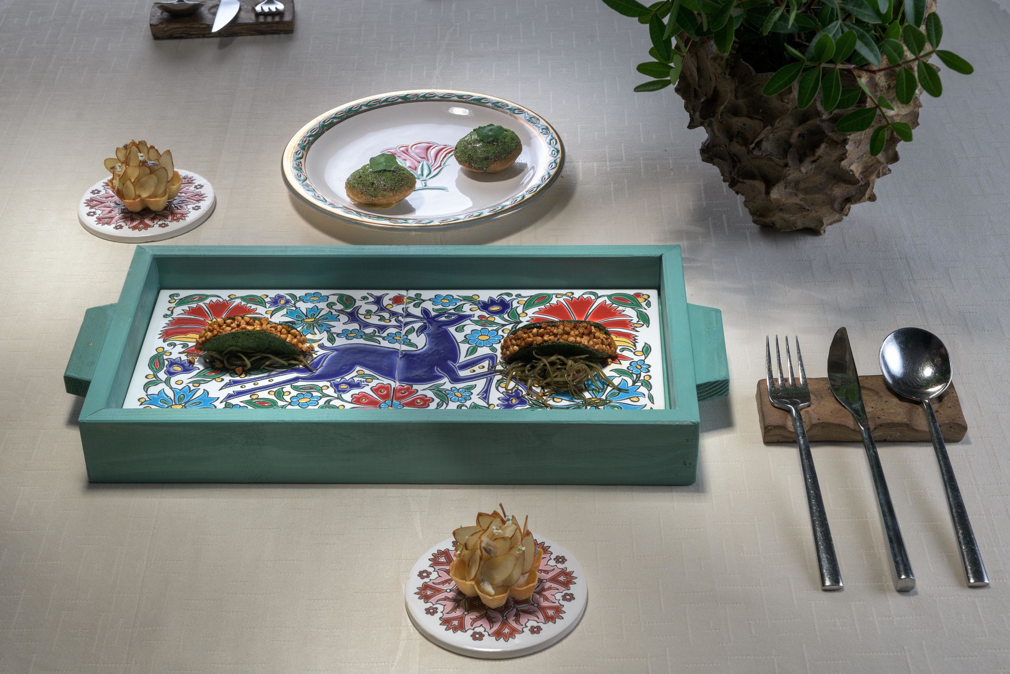 A table set with a decorative tray, plates, and cutlery.
