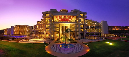 A modern hotel with a central atrium, multiple balconies, and a landscaped courtyard.