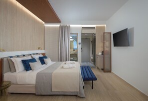 Una habitación de hotel moderna con una cama, una mesita de noche y un televisor montado en la pared.