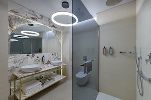 A modern bathroom with a marble vanity, a large mirror, and a glass-enclosed shower area. - Elysium Resort & Spa (Rhodes)