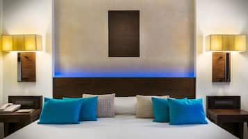 Habitación de hotel con una cama grande, dos mesitas de noche y una lámpara de pared.