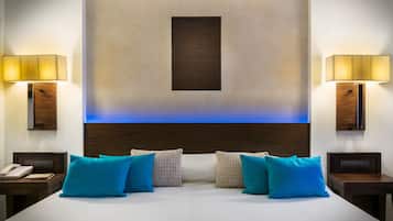 Une chambre d’hôtel avec un grand lit, deux tables de chevet, un téléphone et un luminaire fixé au mur.