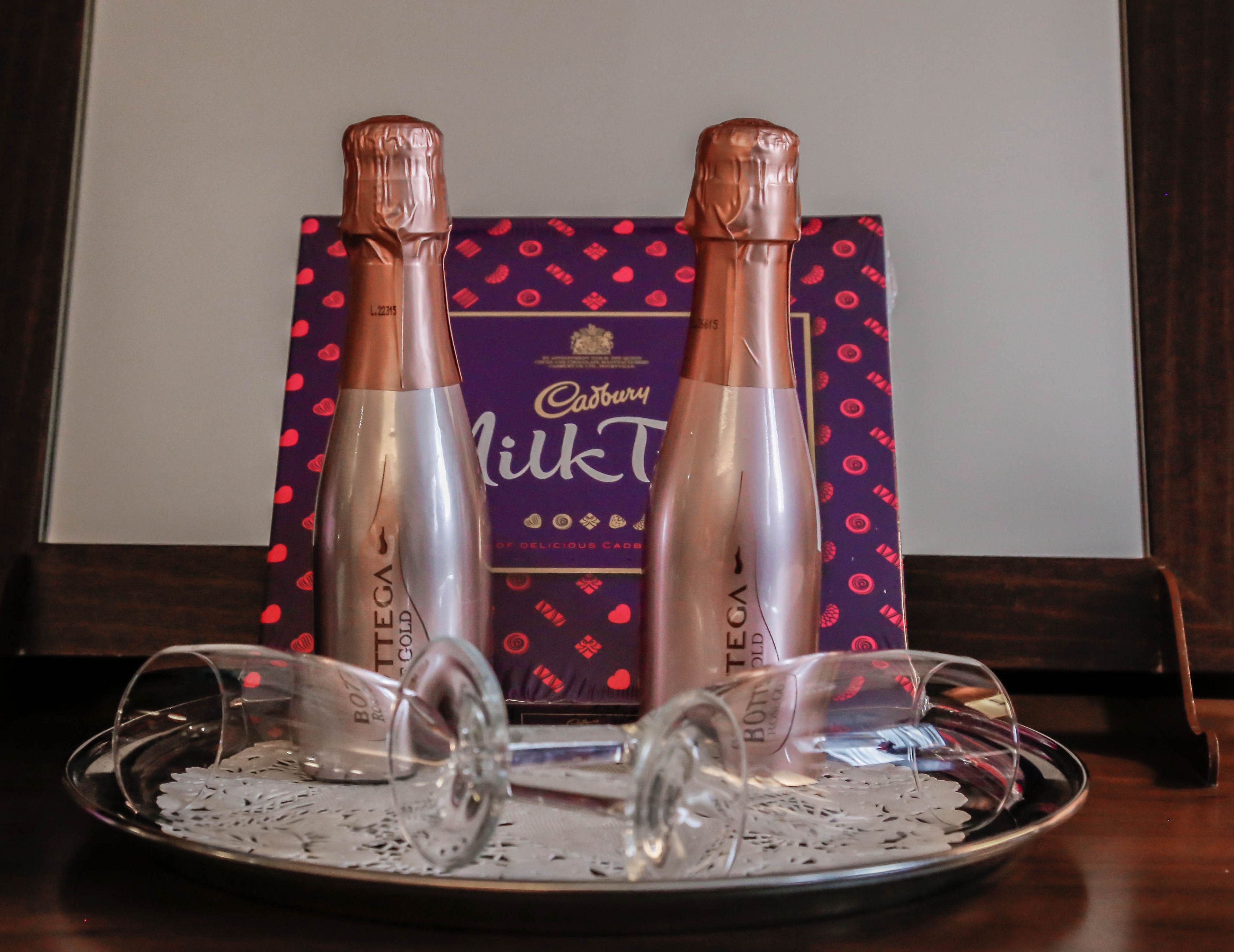Dos botellas de Cadbury Milkt sobre una bandeja con dos vasos.