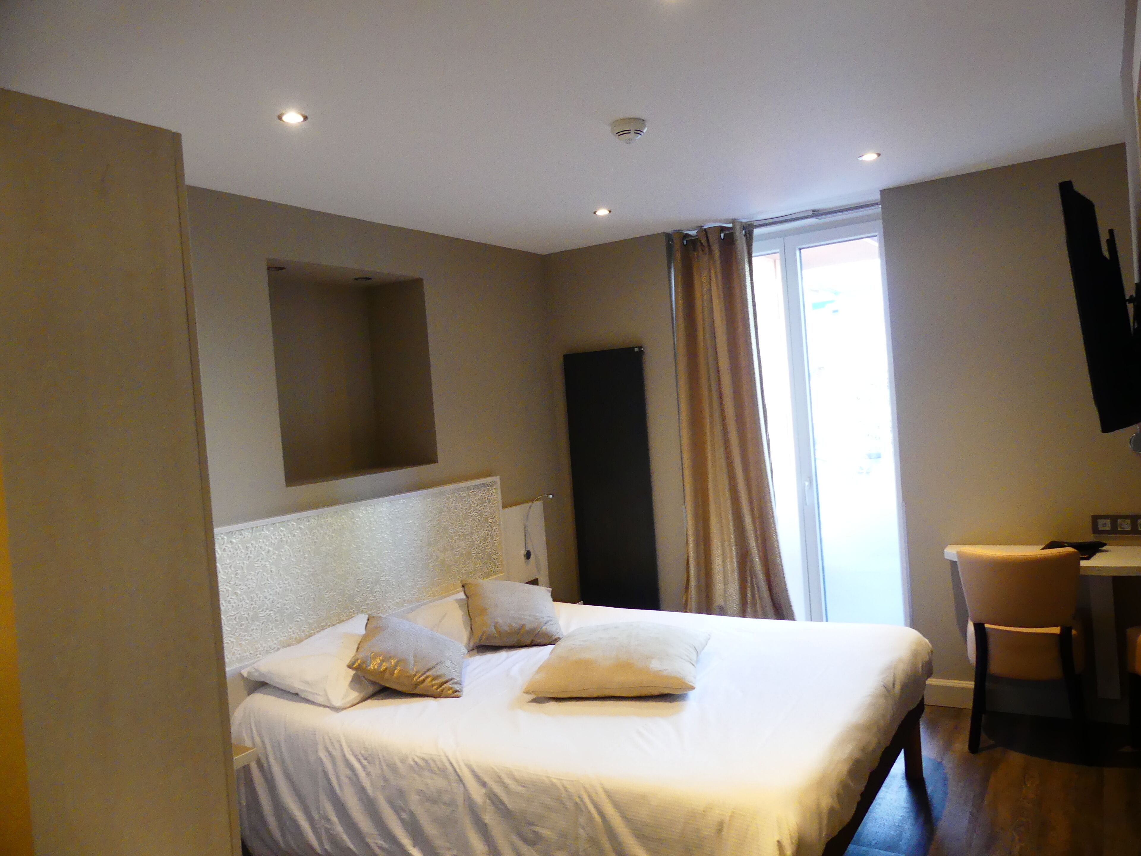 Ein Hotelzimmer mit einem großen Bett, einem Schreibtisch und einem Stuhl.