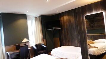 A hotel room with two beds, a desk, a chair, and a wardrobe.