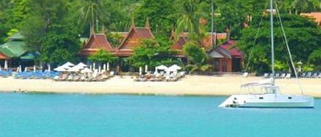 On the beach, white sand, sun loungers, beach umbrellas