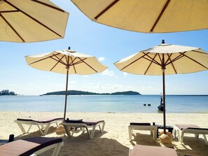 On the beach, white sand, sun loungers, beach umbrellas