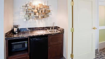 A compact kitchen with a built-in microwave, a dishwasher, and a sink.