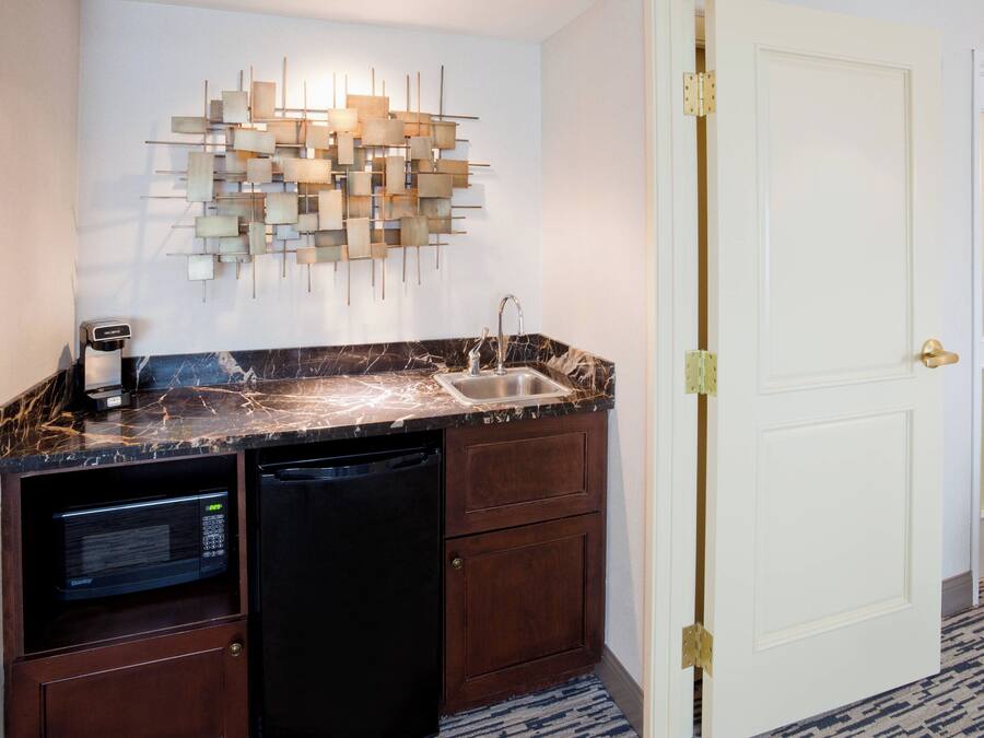 A compact kitchen with a built-in microwave, a dishwasher, and a sink.